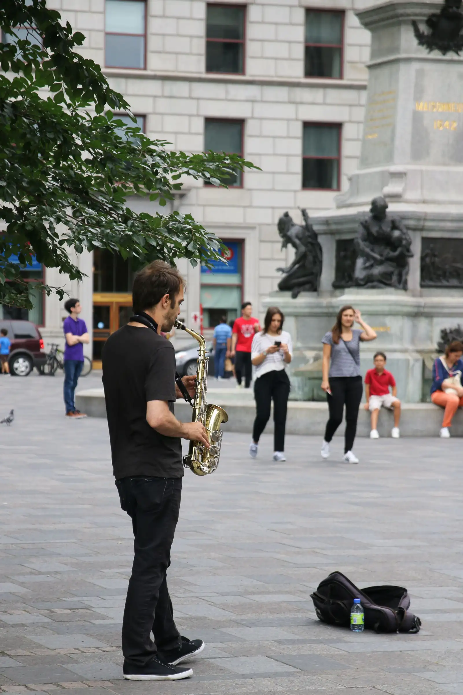 A saxophonist performing in a public square in Montreal