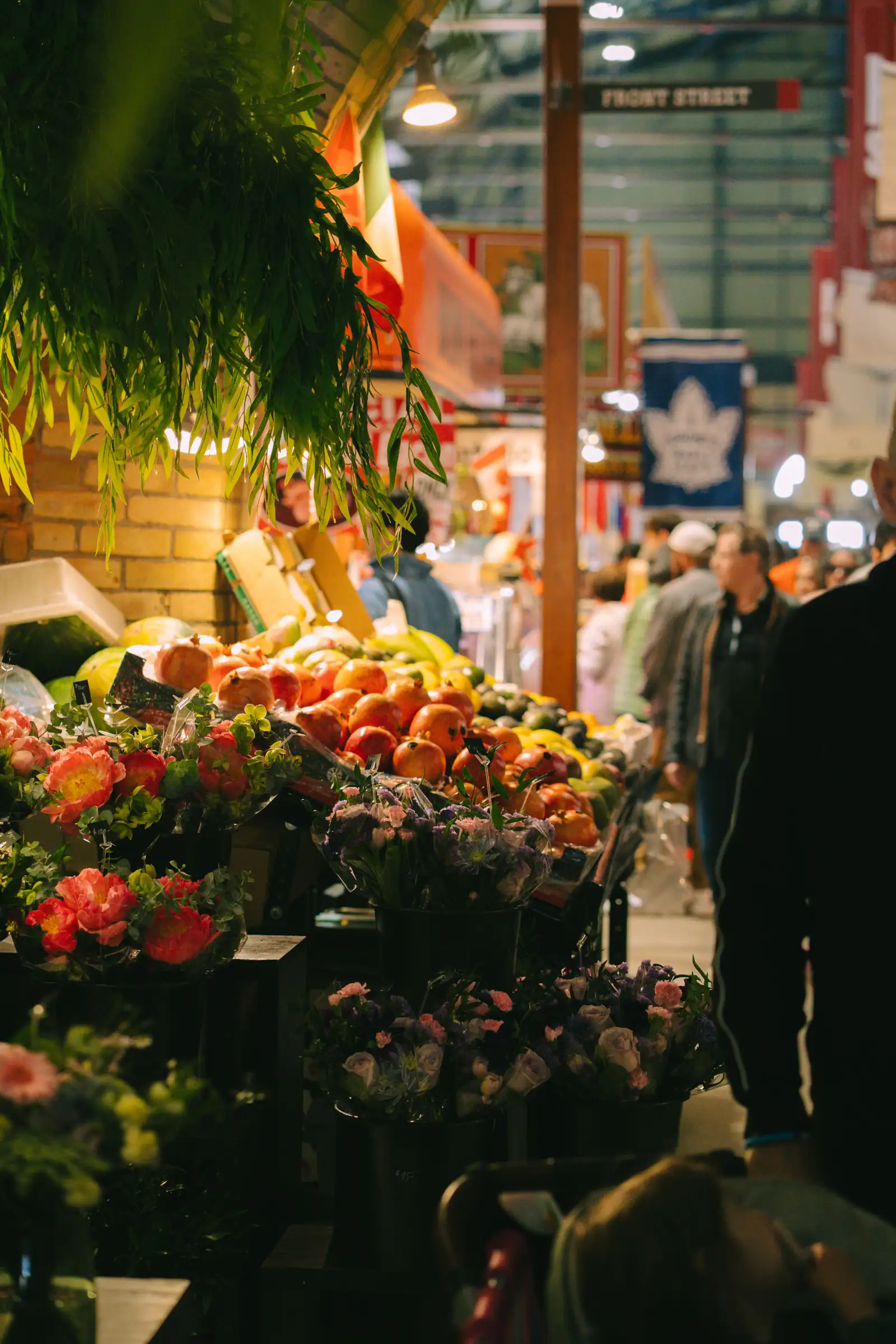 Fresh fruit, flowers and shoppers inside a busy indoor market in Toronto