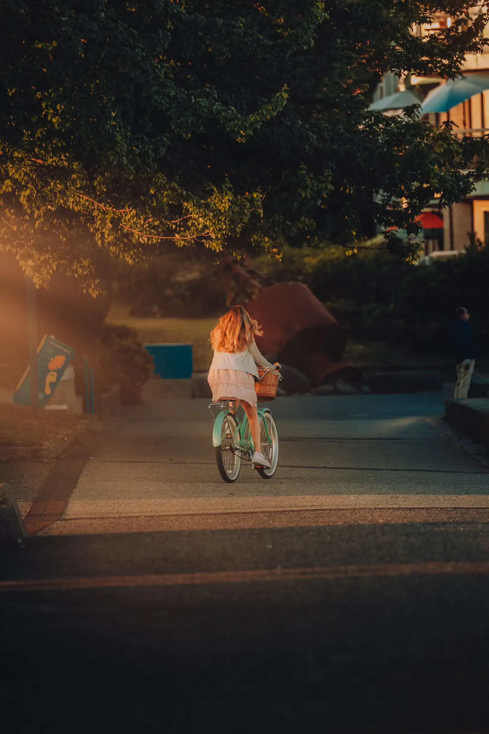 A young child cycling along a sunlit park path in Vancouver